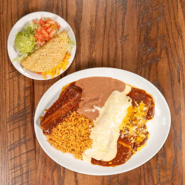 A taco with guacamole and salsa, and a plate of enchiladas with rice and beans.