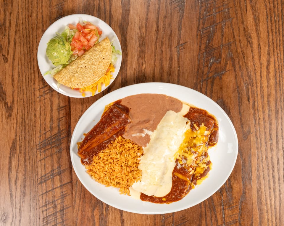 A taco with guacamole and salsa, and a plate of enchiladas with rice and beans.