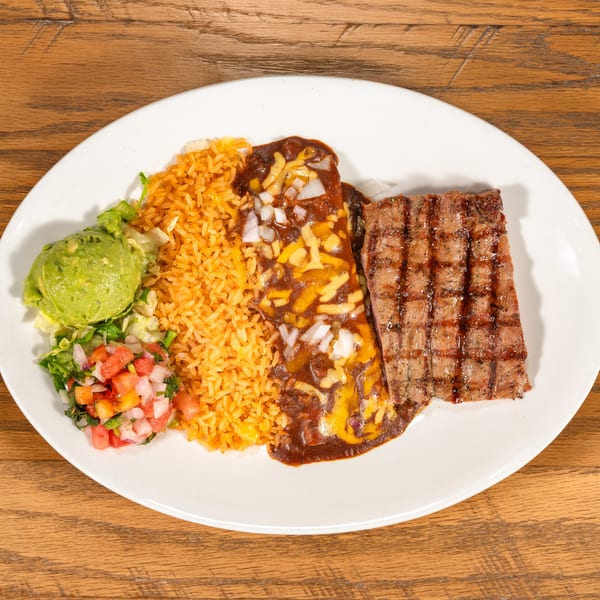 Grilled steak, enchilada, rice, guacamole, and pico de gallo on a white plate.