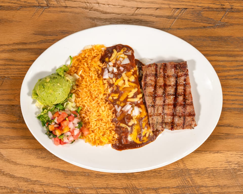 Grilled steak, enchilada, rice, guacamole, and pico de gallo on a white plate.