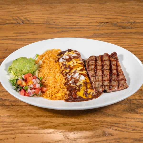 Grilled steak, cheesy enchilada, rice, guacamole, and pico de gallo on a white plate.