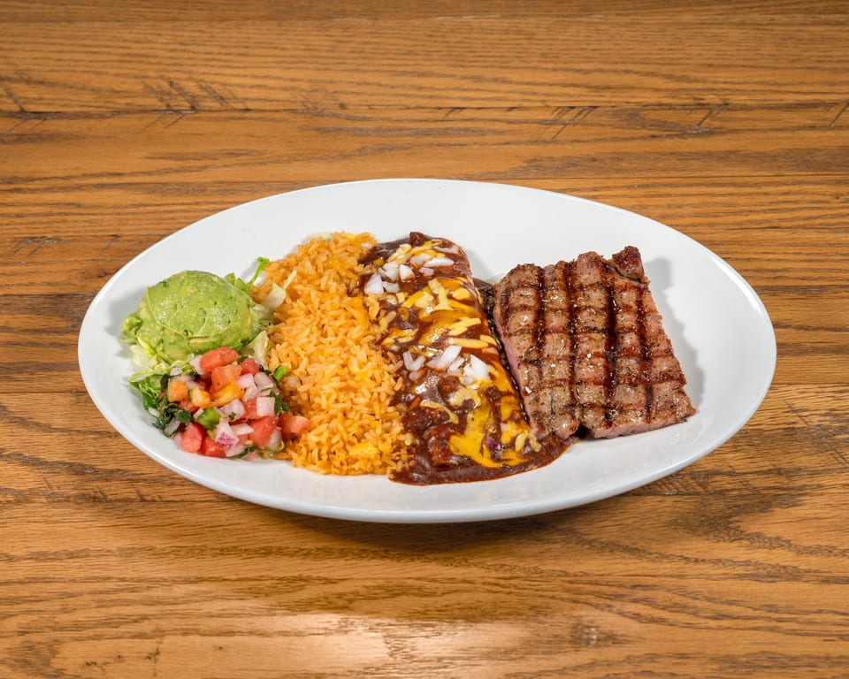Grilled steak, cheesy enchilada, rice, guacamole, and pico de gallo on a white plate.