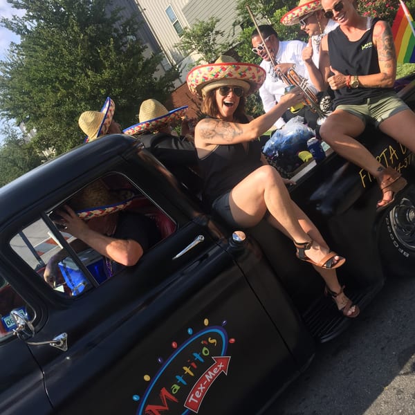 People in sombreros ride in a black Mattito's Tex-Mex truck during a parade.