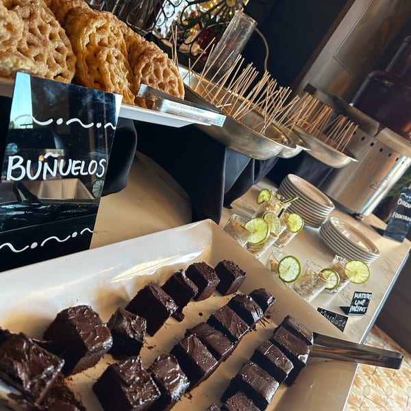 Dessert buffet with buñuelos, chocolate brownies, lime parfaits, and a chocolate fountain.